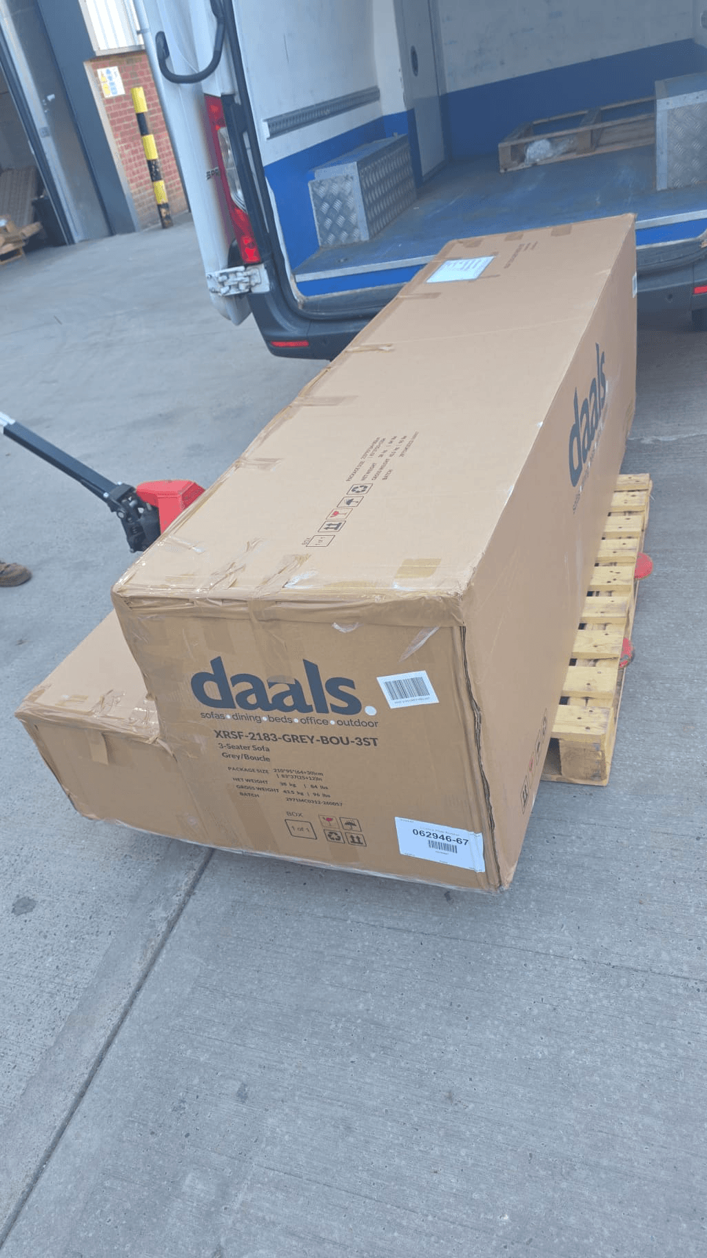 Boxed sofa being loaded via tail-lift